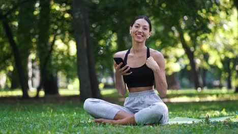 mujer haciendo ejercicio y usando un teléfono móvil al aire libre