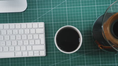 home office desk of a creative professional with coffee and keyboard