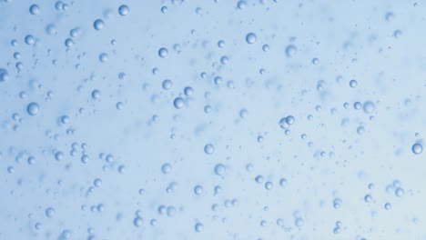 Many-water-bubbles-in-blue-water-close-up,-abstract-water-wave-with-bubbles-in-slow-motion.