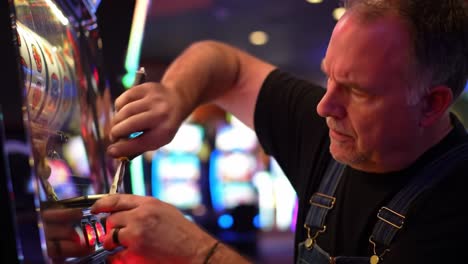 a focused repair technician works intently on a slot machine, demonstrating expertise and precision in a vibrant casino environment