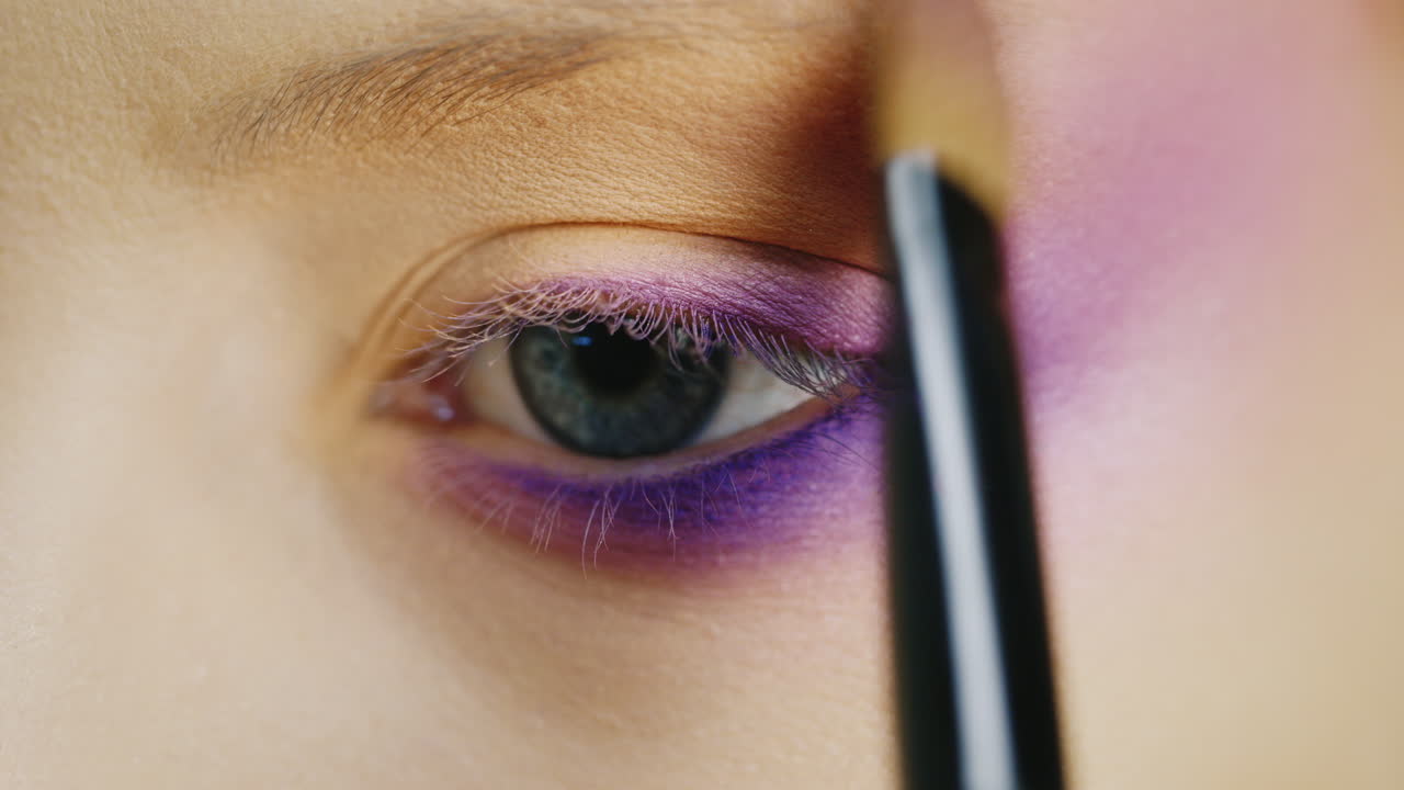 aplicar maquillaje en un hermoso ojo femenino de color azul