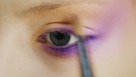 aplicar maquillaje en un hermoso ojo femenino de color azul