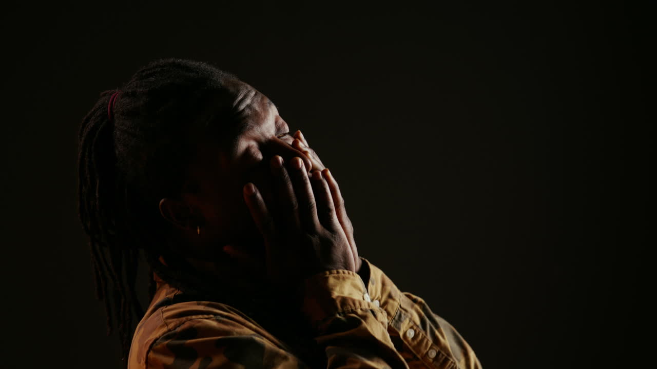 Lazy male model feeling sleepy on black background