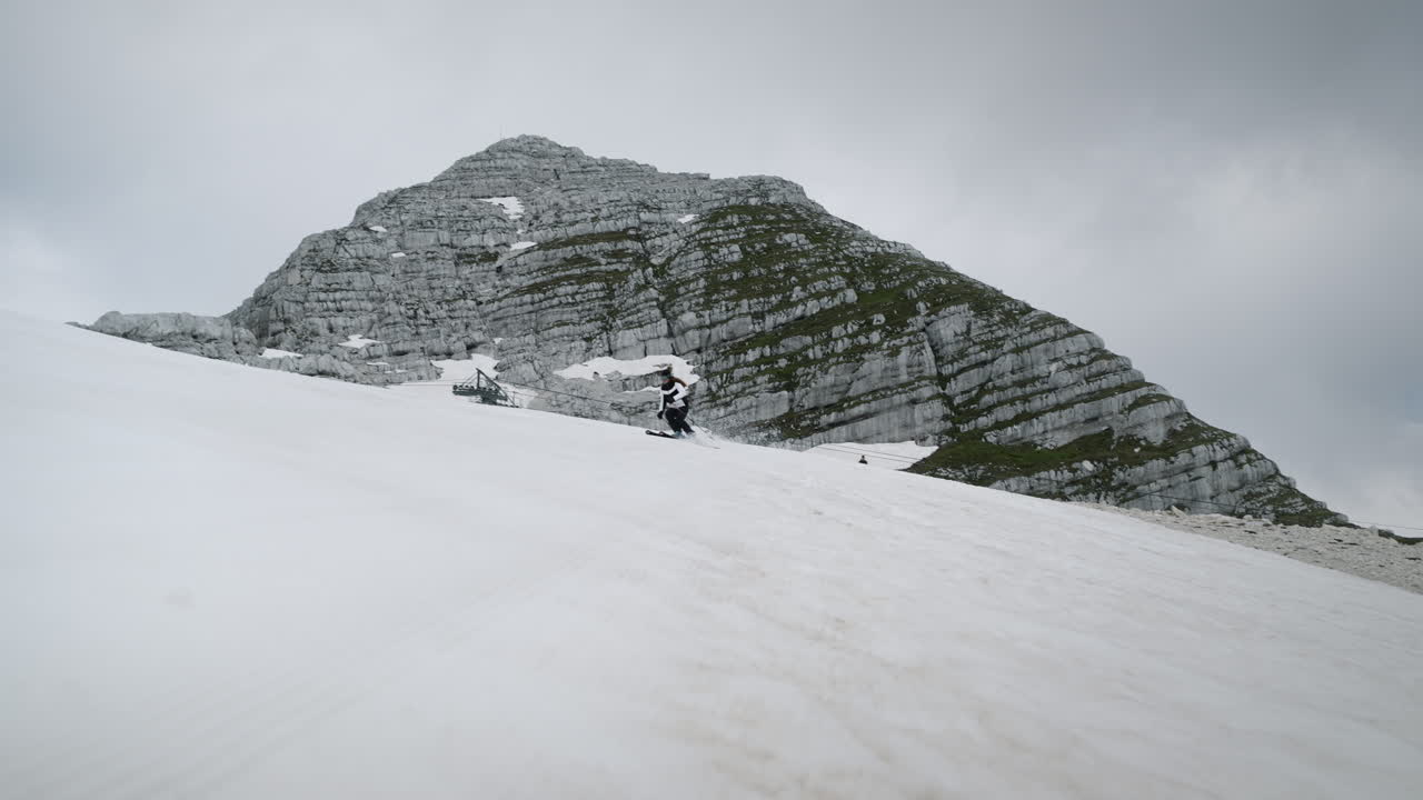 mujer skiis en montaña kanind cuesta abajo en laderas nevadas hacia la cámara