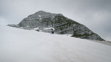 woman skiis on mountain kanind downhill on snowy slopes towards the camera