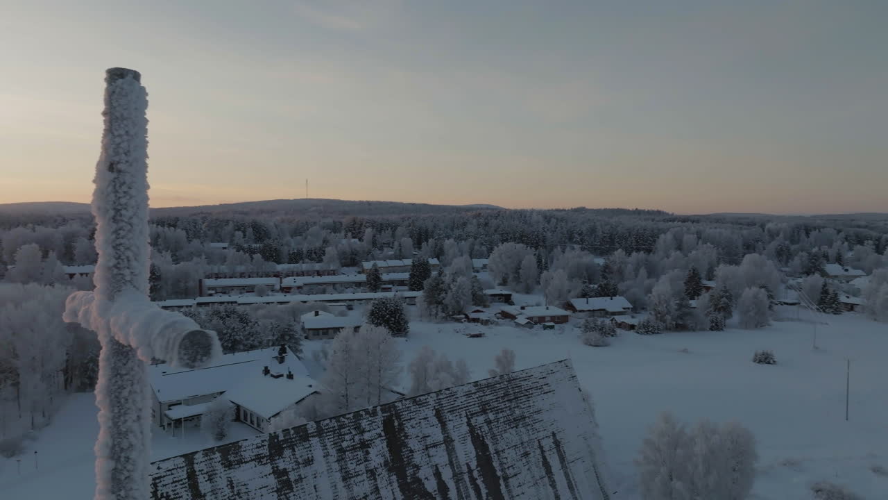 Drone flying around the frozen cross on the Salla church, sunset in Finland