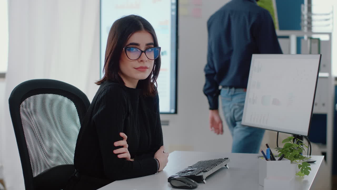 Portrait of businesswoman sitting at desk with computer