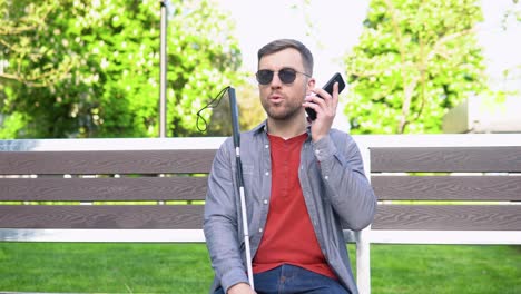 blind man with disability using digital assistant and ease of access functions on smartphone