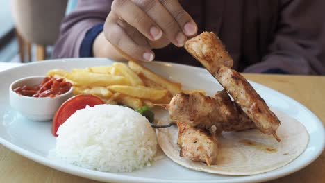 chicken skewers with rice and fries