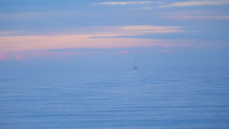 boat seen in distance floating in sea off the costa del sol during evening twilight hours