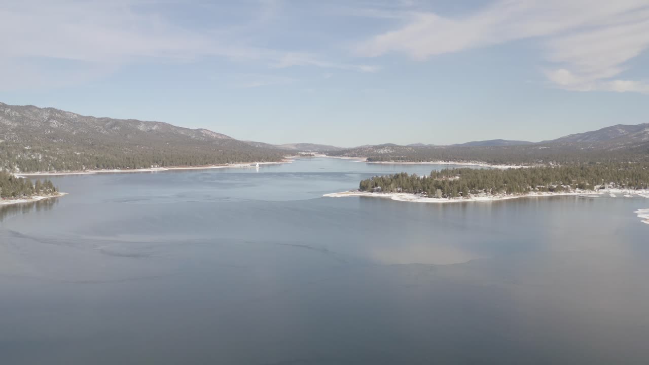 big bear icy lake by drone with snowy trees