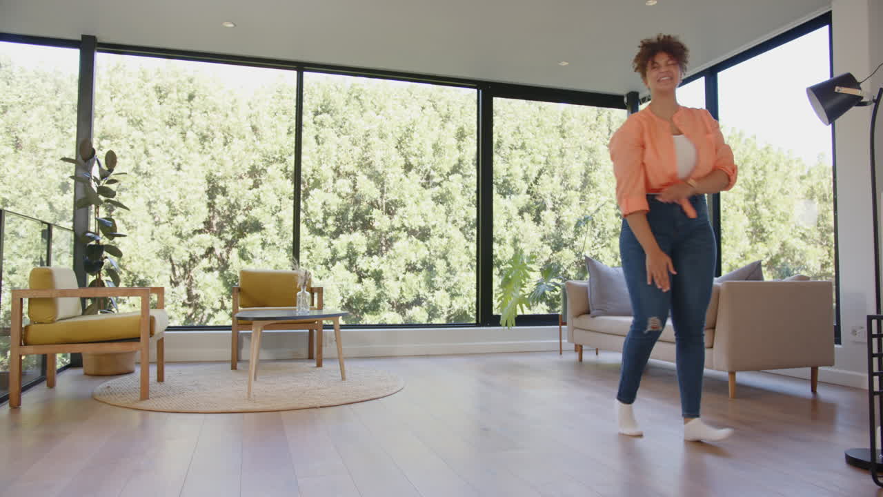 Enjoying fitness routine, plus size woman dancing energetically in modern living room