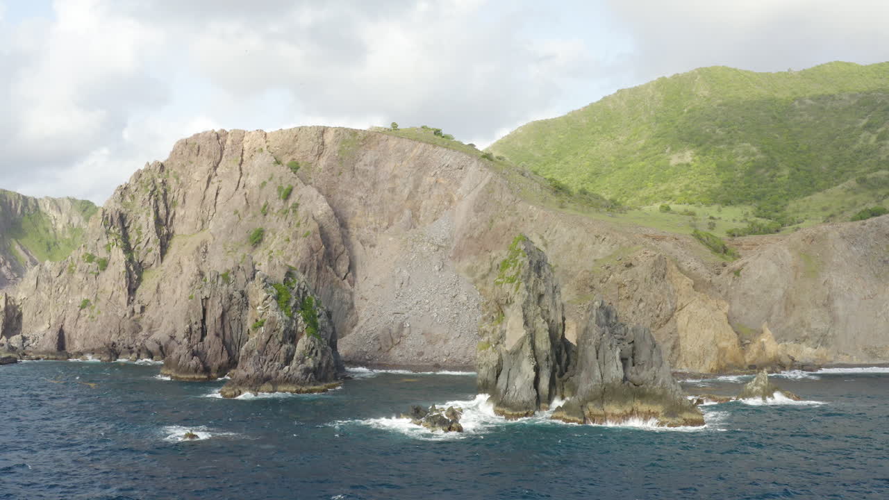 Abandoned Caribbean beach in the early morning. Smooth orbit around three large rocks in the blue ocean in front of a cliffside. Part 2 of 2.4K UHD at 23.98 fps