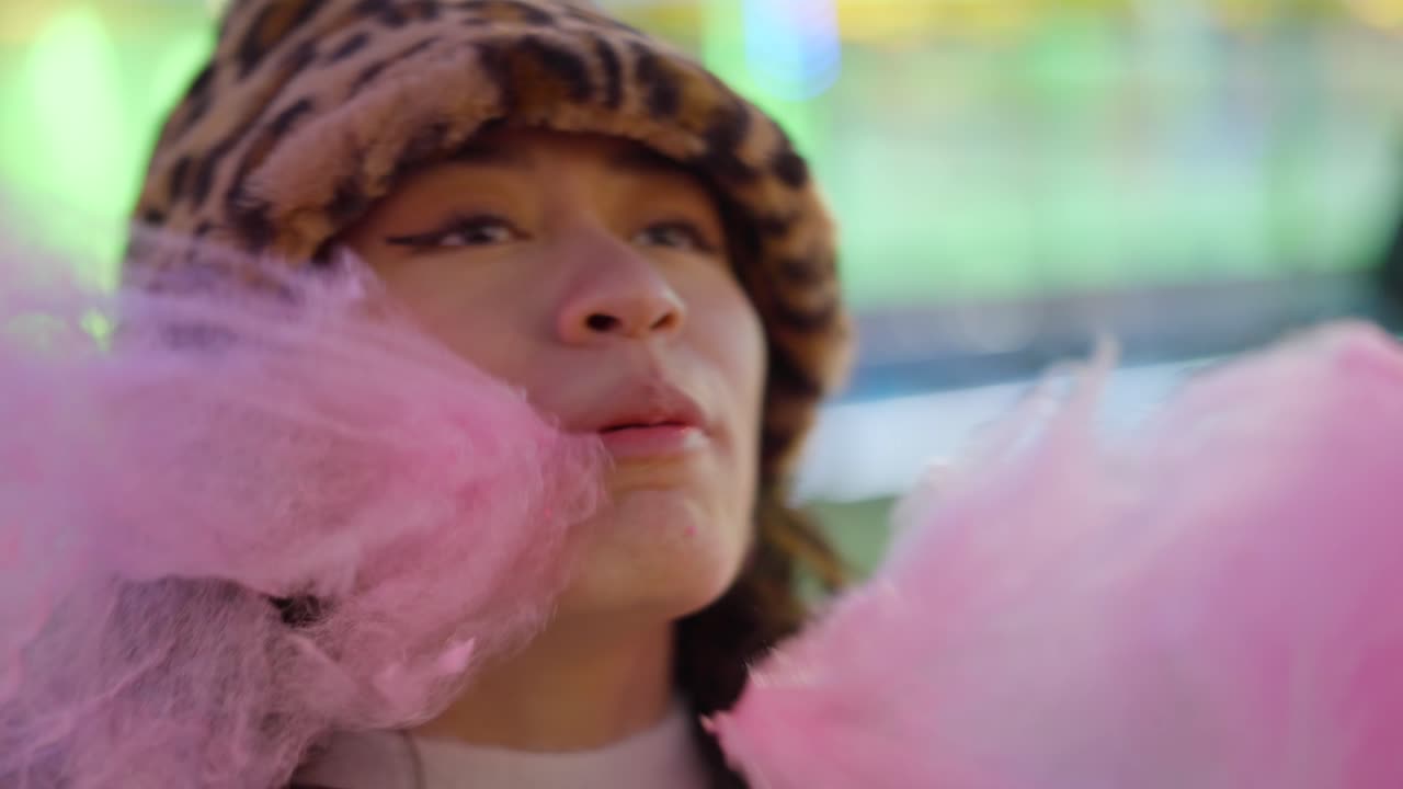 Woman enjoying cotton candy at night