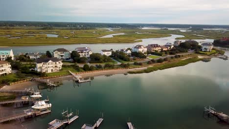 early morning sunrise drone flyover to the left over piers and houses at figure eight island inner harbor in wilmington north carolina