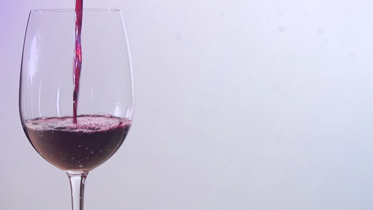 Animazione di neve che cade su bicchiere di vino su sfondo bianco