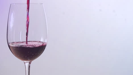 animation of snow falling over glass of wine on white background