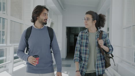 two students talking in a university hallway