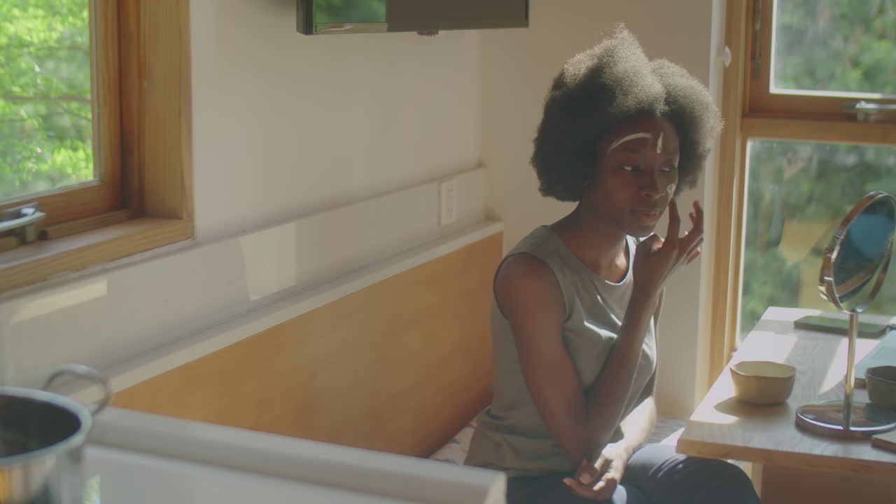 Black Woman Applying Mask to Facial Skin at Home
