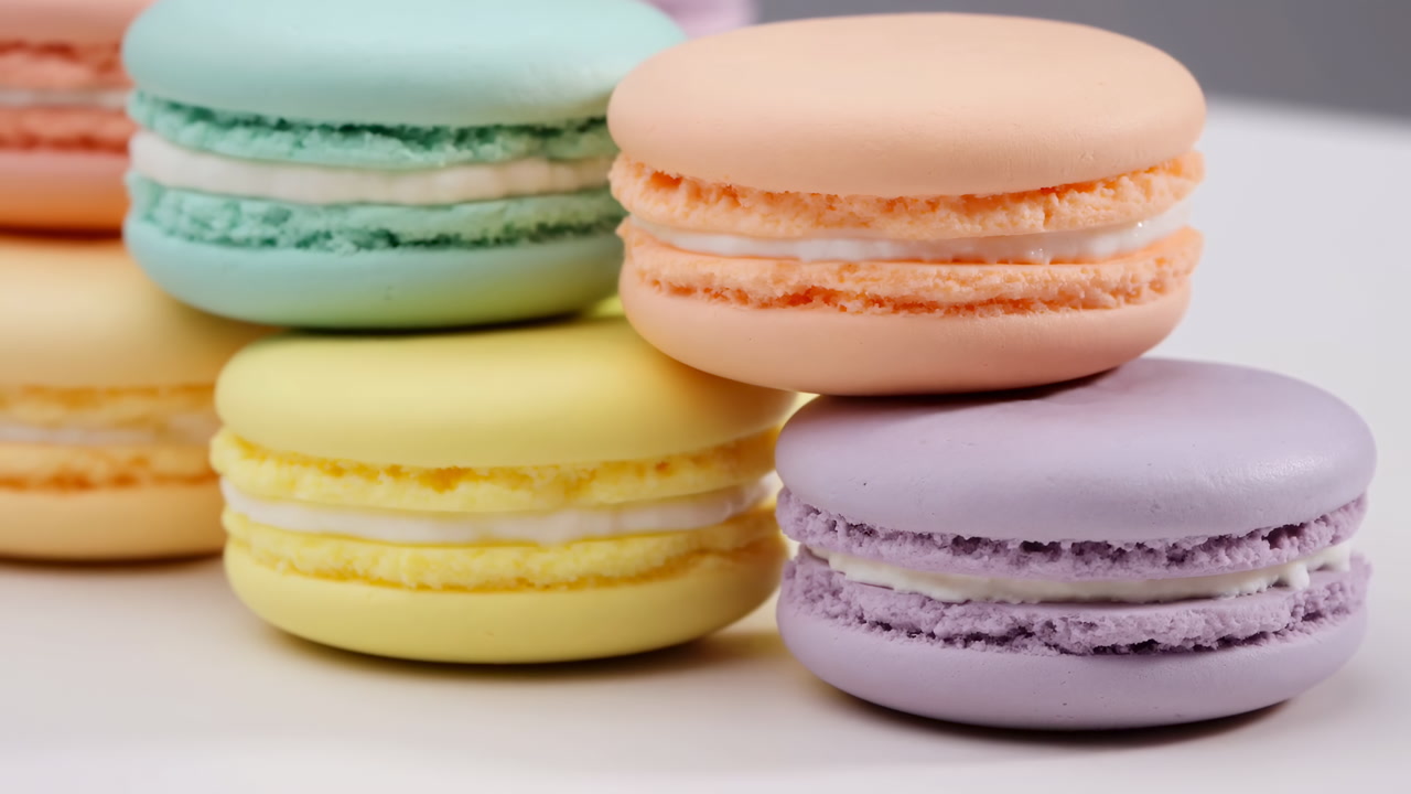 Pastel Macarons Stacked On White Studiolit Closeup Featuring Peach Mint Lemon Lavender Shells With Creamy