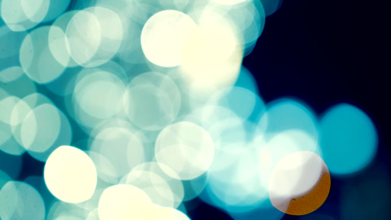 movimiento de grúa de un hermoso bokeh de color, las luces hacen un bokeh de color abstracto como galaxia, círculo de luz amarillo y azul, la cámara se mueve hacia arriba