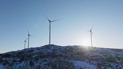 Molinos-De-Viento-Para-La-Producción-De-Electricidad-En-Una-Montaña-Nevada-En-Bessaker,-Noruega---Disparo-De-Un-Dron