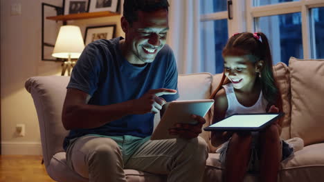 father and daughter enjoying tablet time together at home