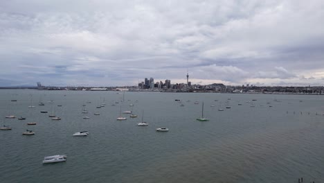 aerial shot of auckland cbd and sky tower with the waitemata harbour and boats 4k