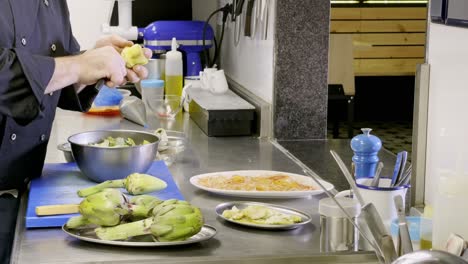 cutting and pealing artichokes in restaurant's kitchen, high cuisine