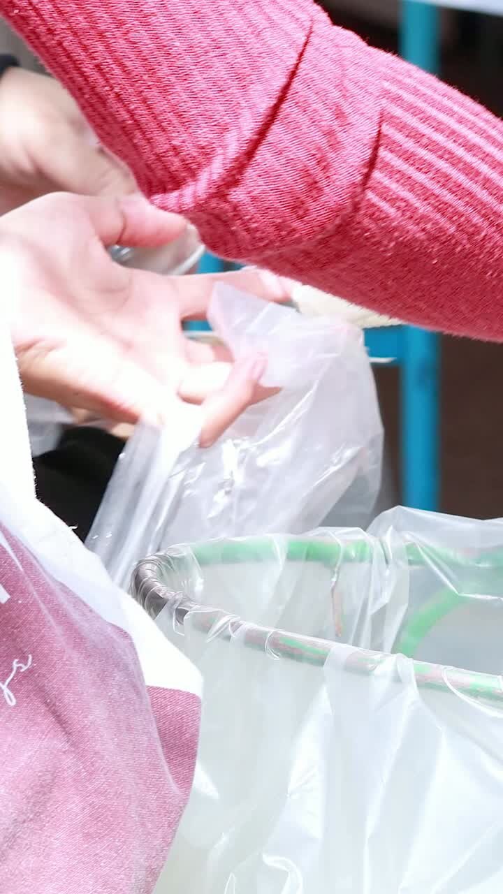 People sorting waste into recycling bins at park event