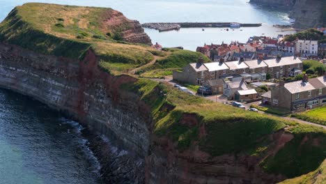 aerial drone view of staithes harbour on the north yorkshire coast with river,houses, boats on a sunny morning in august, summertime