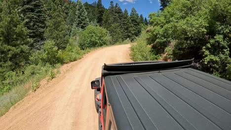 pov - view of vehicle rooftop while driving on a scenic byway in rocky mountains