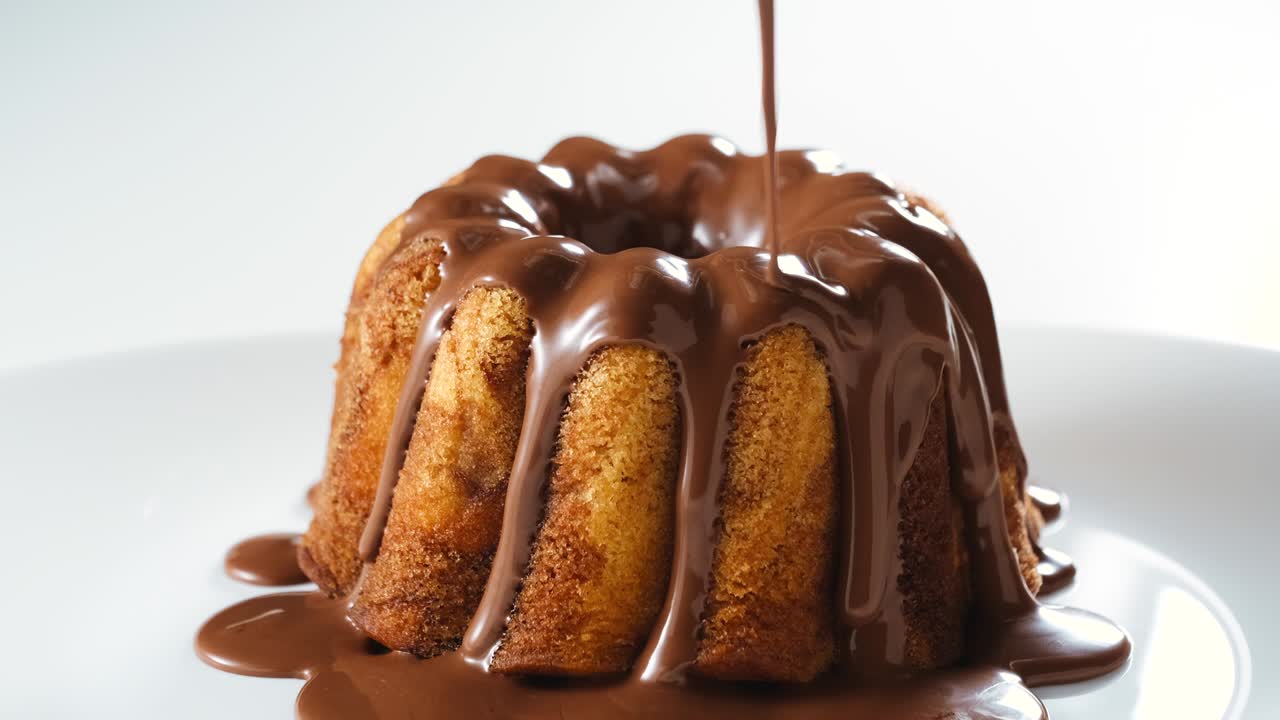 vertiendo la guinda de nougat de chocolate en el pastel de mármol