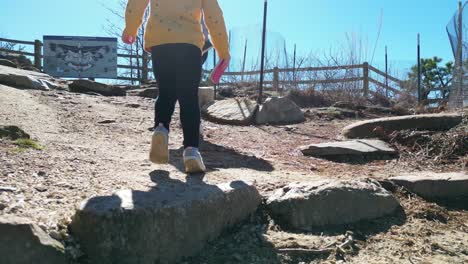 niño caminando detrás de la madre hasta pilot mountain en mount airy carolina del norte