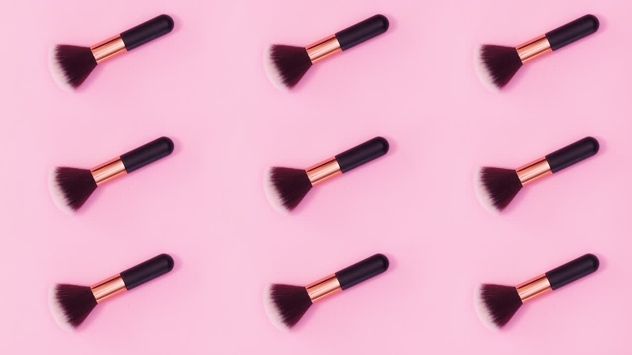 Beauty concept pattern made of make up brushes move on bright pink background. Stop motion