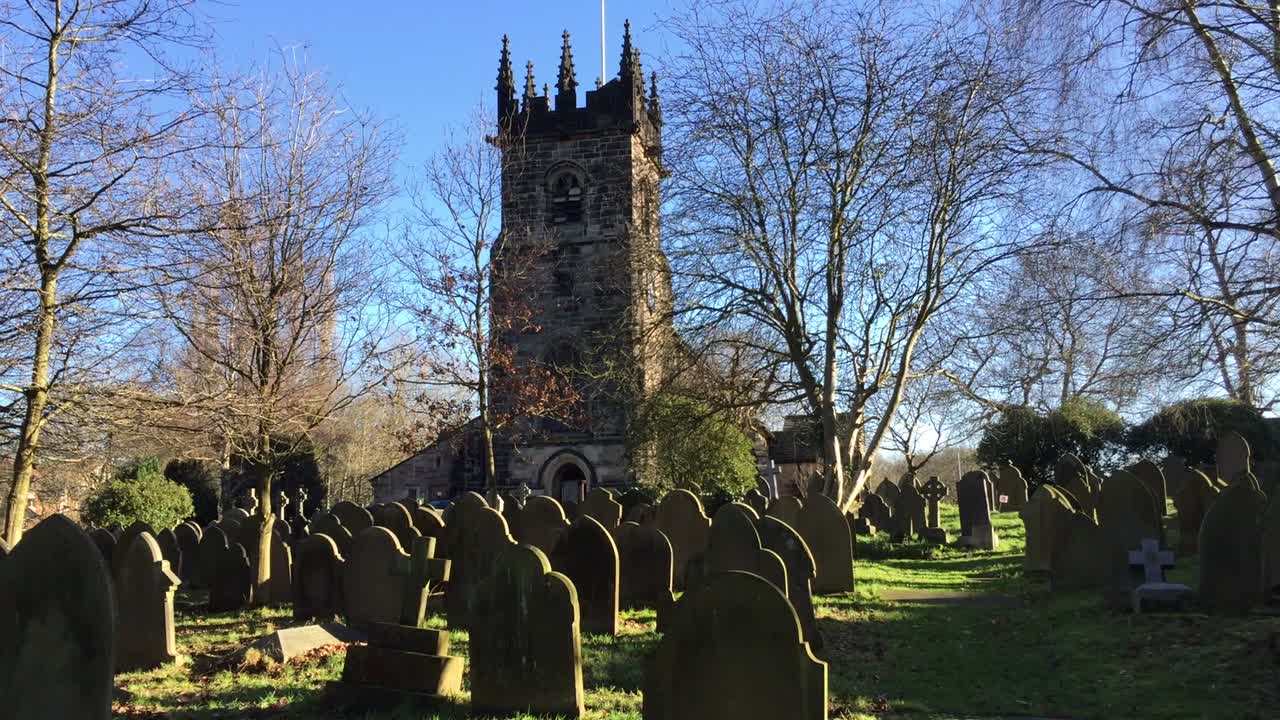 Bright winter view of St Bartholomew's Church in the town of Wilmslow, Cheshire, England, from the graveyard. The church is recorded as a designated Grade I listed building.