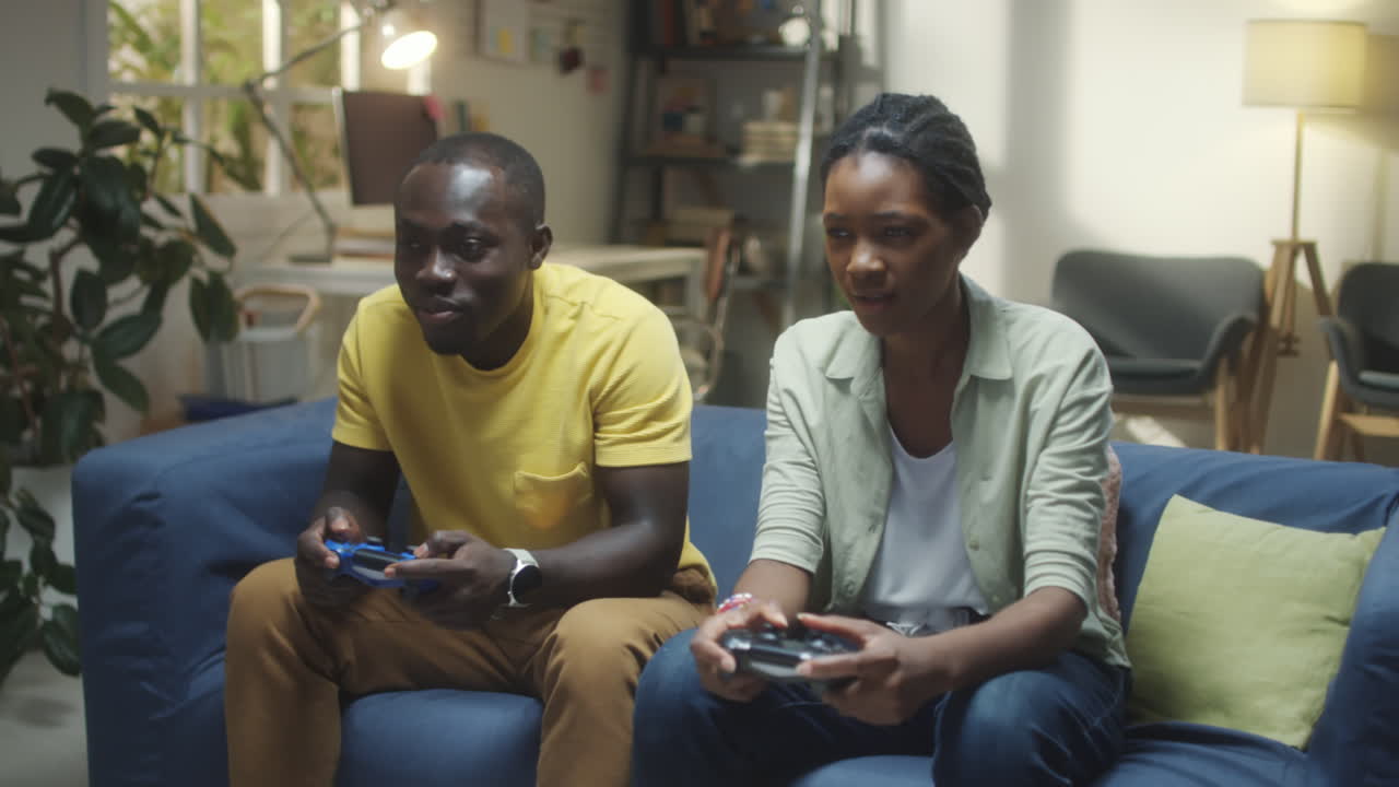 Um casal feliz jogando videogames juntos em um sofá