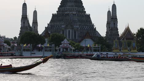 speedboats racing by a traditional thai temple