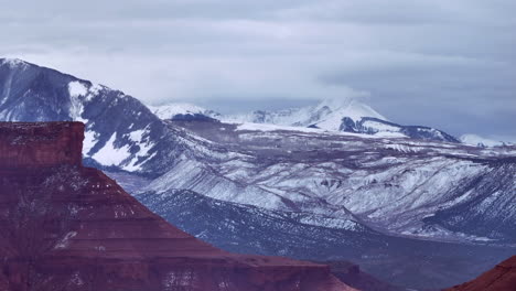 Toma-Aérea-Meseta-Del-Desierto-De-Moab-Y-Montañas-Nevadas-La-Sal