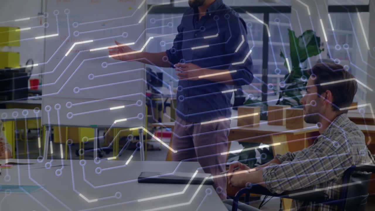 Male presenter highlighting whiteboard in tech meeting, team taking notes under circuit overlay