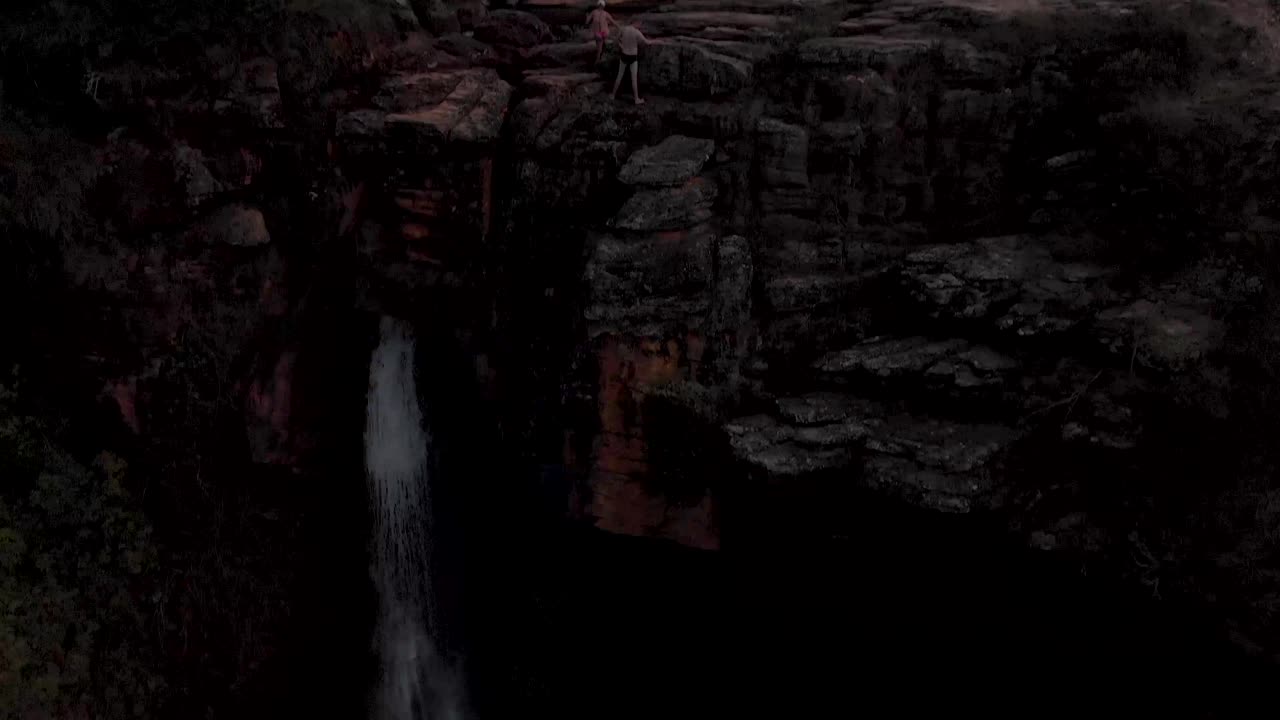 Approaching a rock plateau river bed with stream of a river cascading revealing the tall waterfall in the foreground in the Andorinhas national park near Ouro Preto, Minas Gerais, Brazil