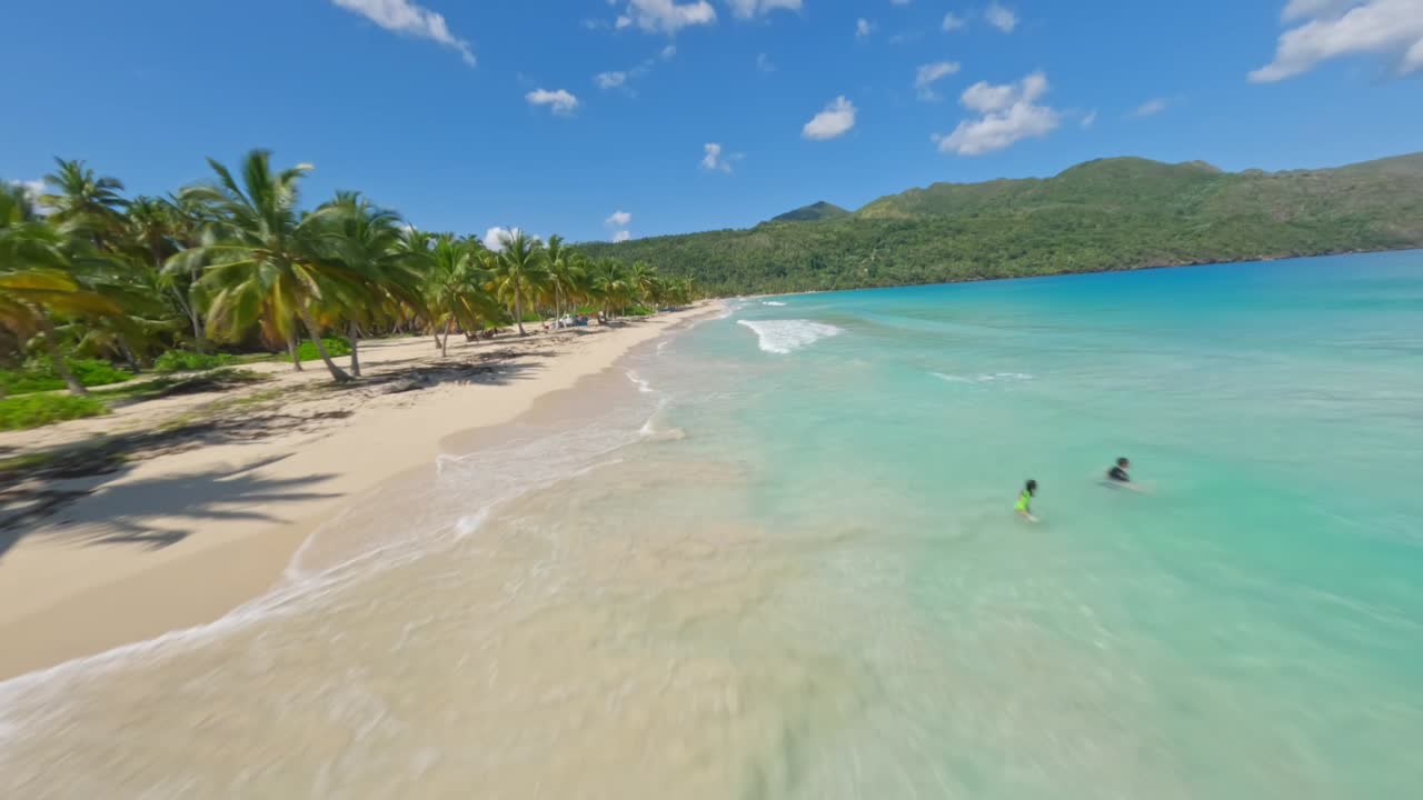 Fast FPV drone racing over remote exotic golden sand beach Caribbean paradise