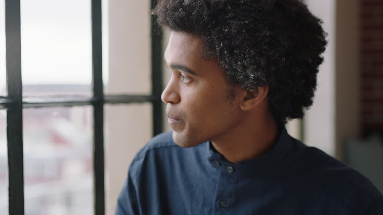 portrait young businessman drinking coffee at home entrepreneur enjoying calm relaxed morning looking out window thinking contemplative trendy afro hairstyle
