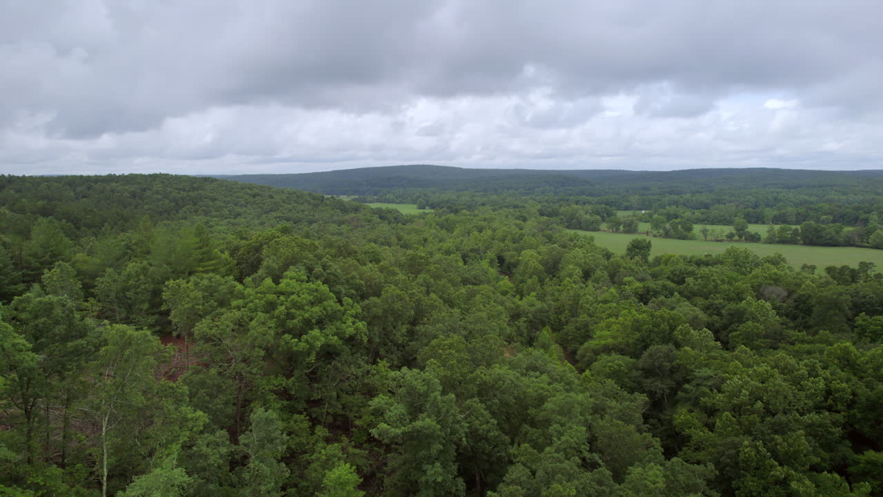 Aerial with slow pan over beautiful southern Missouri landscape on a cloudy summer day
