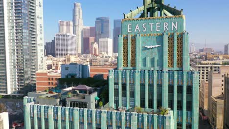 aerial of the historic eastern building in downtown los angeles with clock and downtown city skyline behind 1