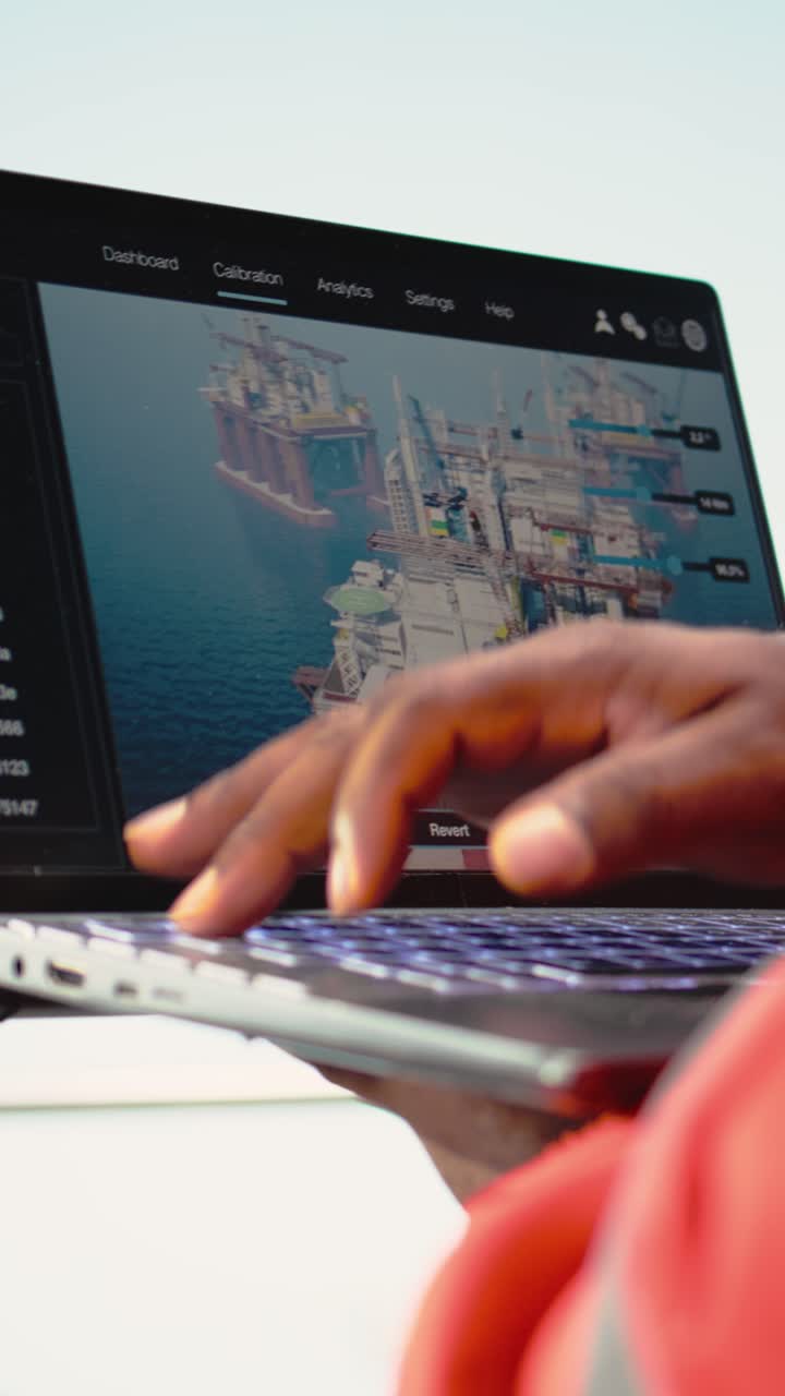 Vertical video Close up of laptop used by drilling rig worker to monitor infrastructure systems