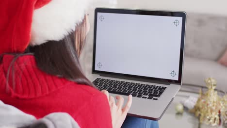 Mujer-Birracial-Con-Gorro-De-Papá-Noel-Usando-Una-Computadora-Portátil-Con-Espacio-Para-Copiar