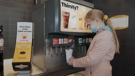 Buffalo, NY, USA, October 2021: A child is filling a glass with a carbonated drink at a McDonald&#039;s restaurant.