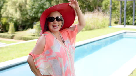 La-Mujer-Asiática-Mayor-Disfruta-De-Un-Día-Soleado-Junto-A-La-Piscina.