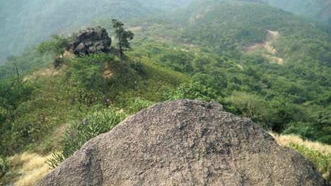 Ariel-view-of-a-mountain-range-in-slow-motion-with-beautiful-green-vegetation-on-a-bright-sunny-day